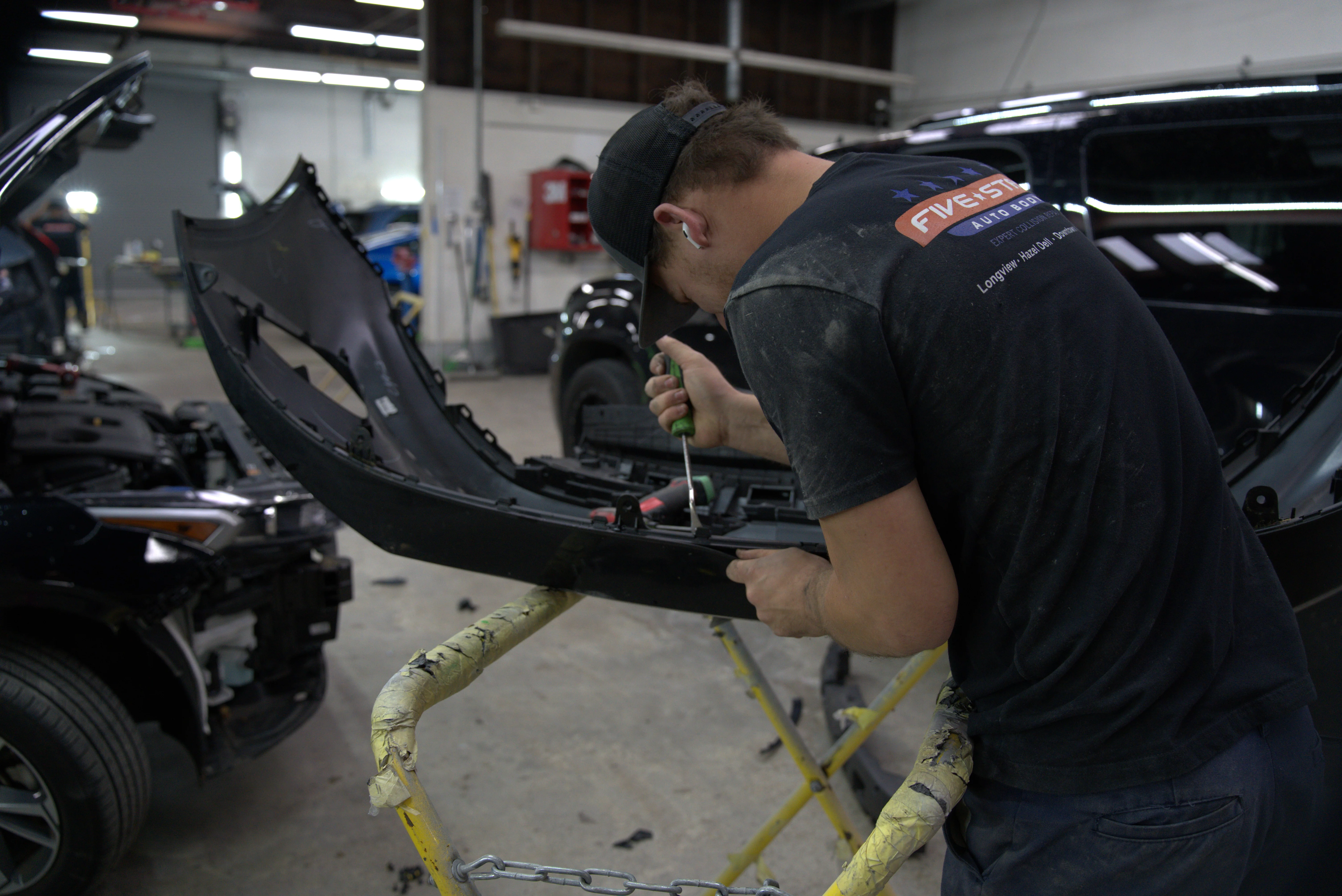 Professional paintless dent repair technician removing door ding at Five Star Auto Body in Vancouver WA